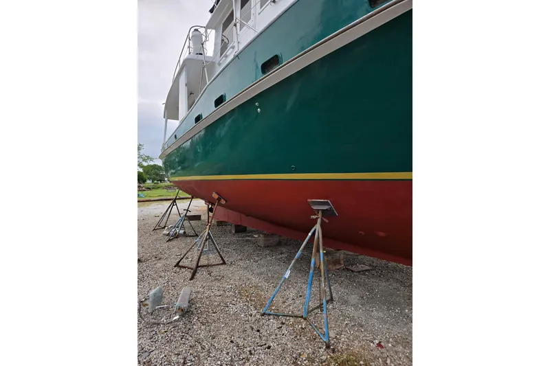 Slide: The Image of 1982 Krogen 42 boat on stands, green and red hull, side view. - 2