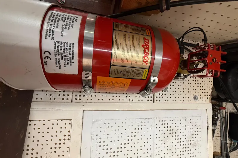 Slide: The Image of Red fire extinguisher mounted on a perforated wall, labeled "Fireboy," in a 1982 Krogen 42. - 20