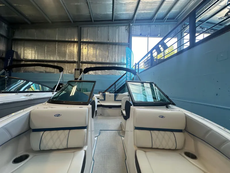 Slide: The Image of 2025 Regal 2000ES Bowrider interior in showroom, featuring sleek white seating. - 18
