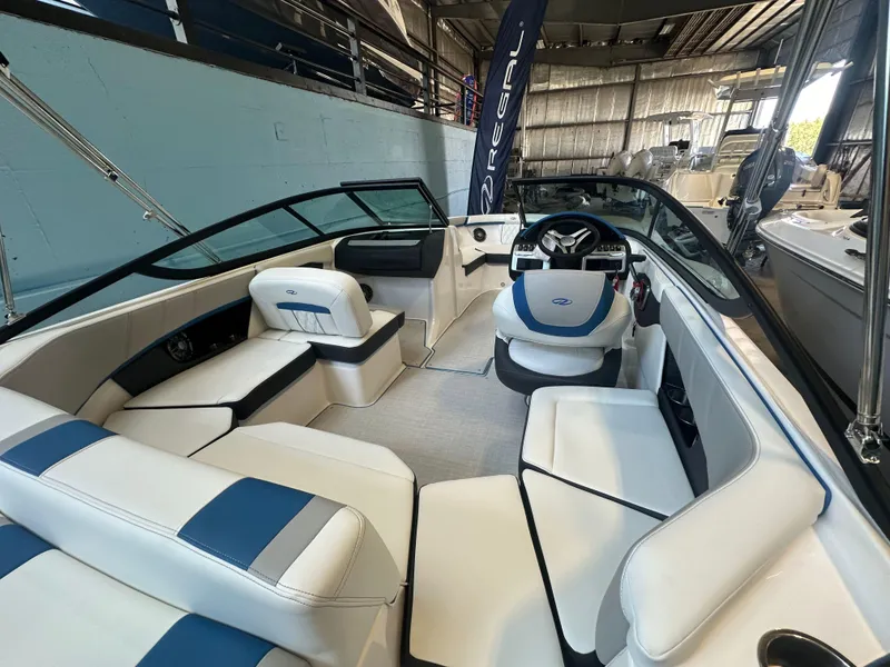 Slide: The Image of 2025 Regal 2000ES Bowrider boat in showroom, rear view, sleek design. - 7