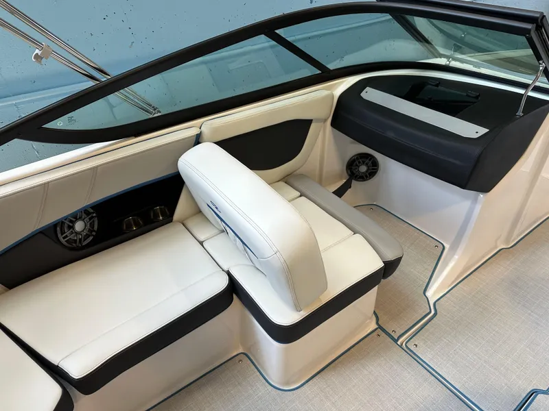 Slide: The Image of 2025 Regal 2000ES Bowrider interior with sleek white and blue seating in a showroom. - 9