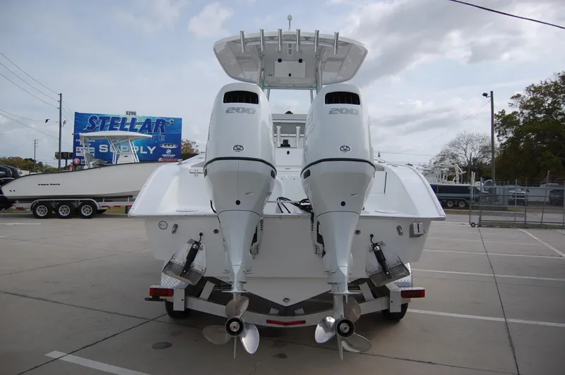 Slide: The Image of 2024 Cape Horn 24 XS boat with dual outboard engines, rear view in a parking lot. - 1
