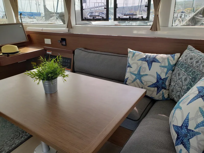 Slide: The Image of Interior of 2019 Lagoon 40 catamaran with cozy seating and nautical-themed cushions. - 10