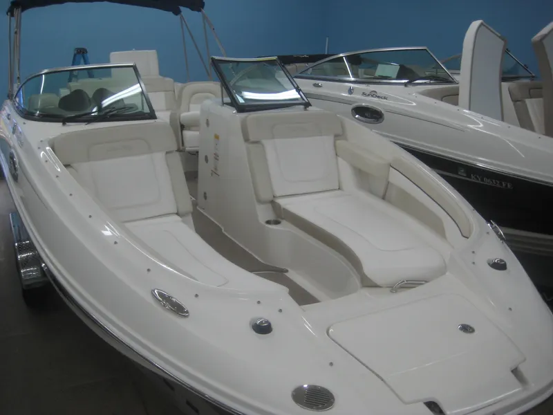 Slide: The Image of A 2013 Sea Ray 260 Sundeck with a white hull and spacious deck, in a showroom. - 6