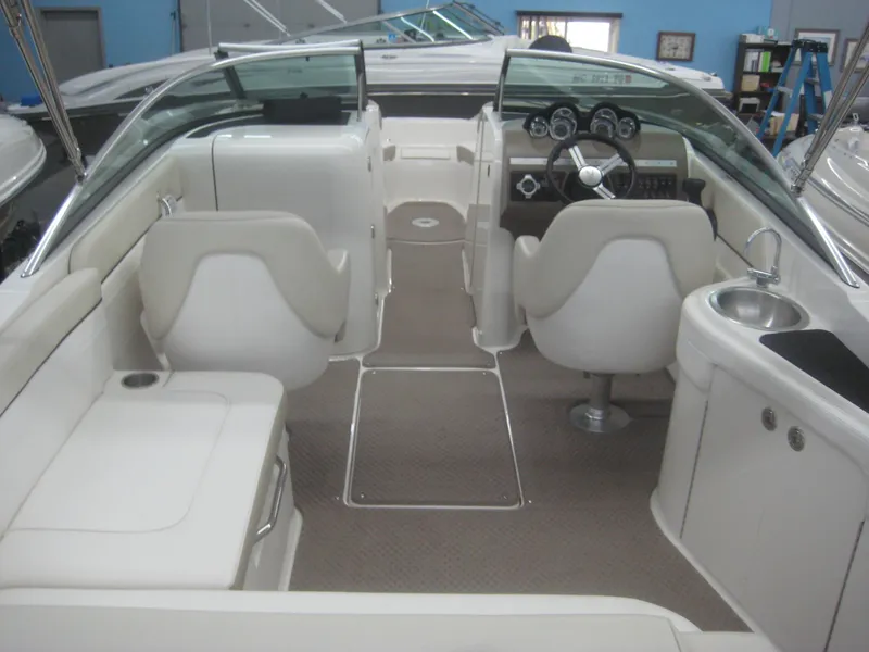 Slide: The Image of The image shows the cockpit of a 2013 Sea Ray 260 Sundeck boat with white seats and a helm. - 10
