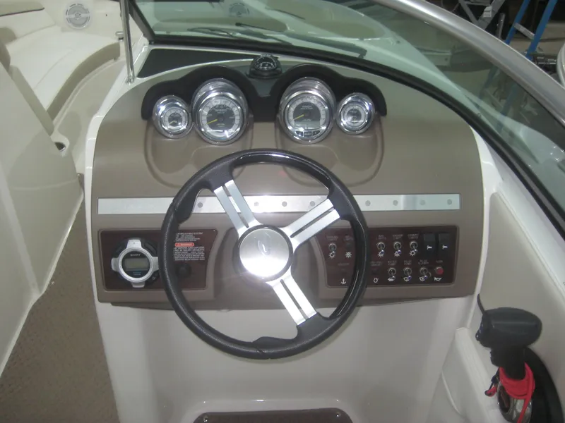 Slide: The Image of The image shows the dashboard of a 2013 Sea Ray 260 Sundeck boat with a steering wheel and gauges. - 11
