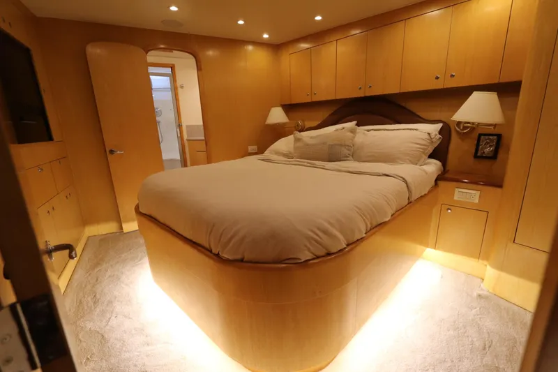 Slide: The Image of Luxurious bedroom interior of 2002 Buddy Davis 74 yacht with cozy lighting and elegant wood finish. - 14