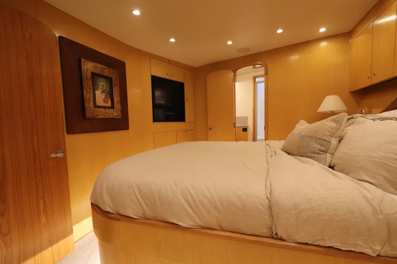 Slide: The Image of Luxurious bedroom interior on a 2002 Buddy Davis 74 yacht, featuring elegant wood paneling. - 16