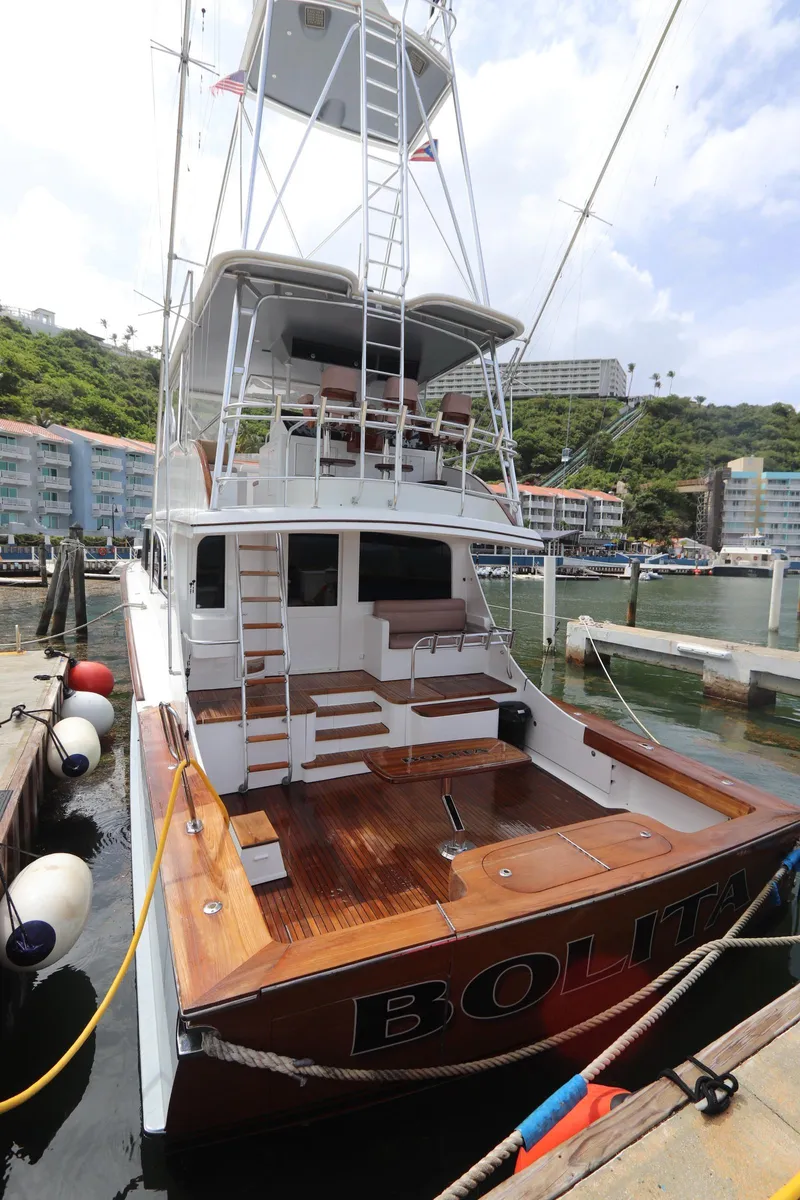 Slide: The Image of Luxury 2002 Buddy Davis 74 yacht docked at marina, featuring spacious deck and tower. - 25