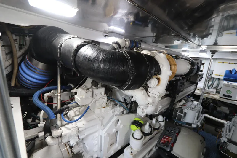 Slide: The Image of Engine room of a 2002 Buddy Davis 74 yacht, showcasing complex machinery and piping. - 32