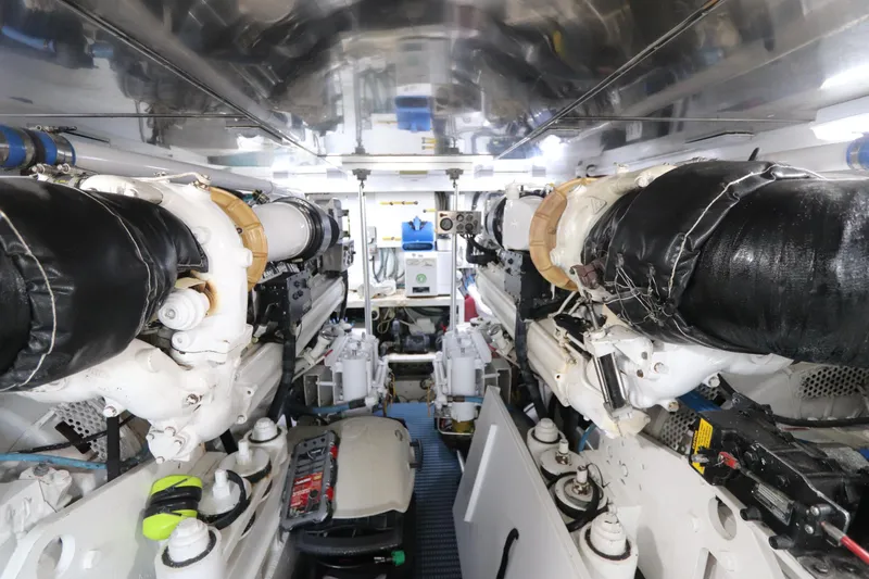 Slide: The Image of Engine room of a 2002 Buddy Davis 74 yacht, showcasing dual engines and mechanical components. - 33