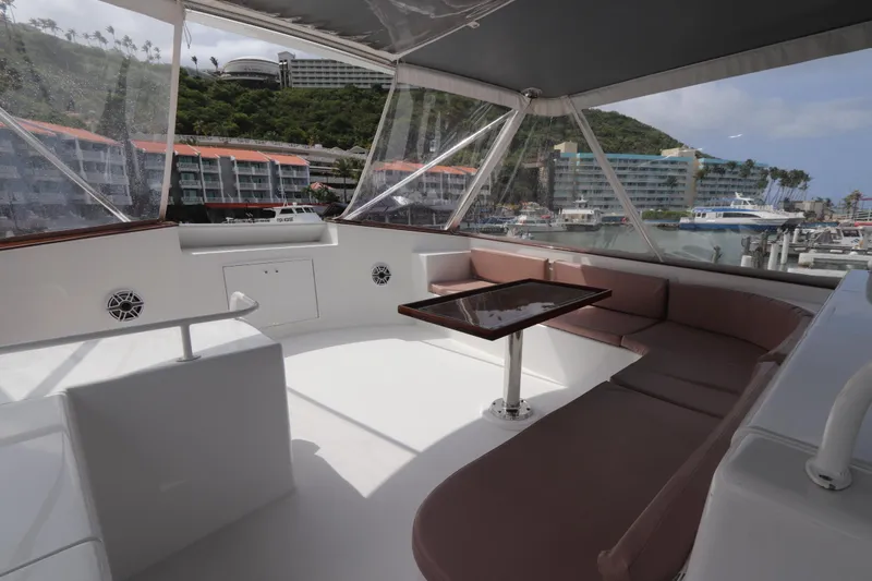 Slide: The Image of Luxurious seating area on a 2002 Buddy Davis 74 yacht, docked at a scenic marina. - 38