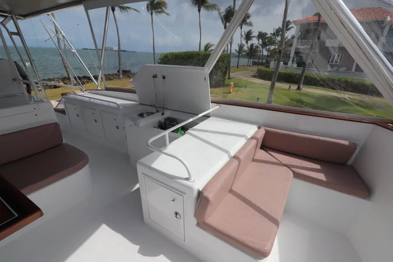 Slide: The Image of Luxurious 2002 Buddy Davis 74 yacht interior with seating, ocean view, and palm trees. - 40