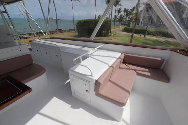 Slide: The Image of Luxurious 2002 Buddy Davis 74 yacht interior with seating, ocean view, and palm trees. - 41