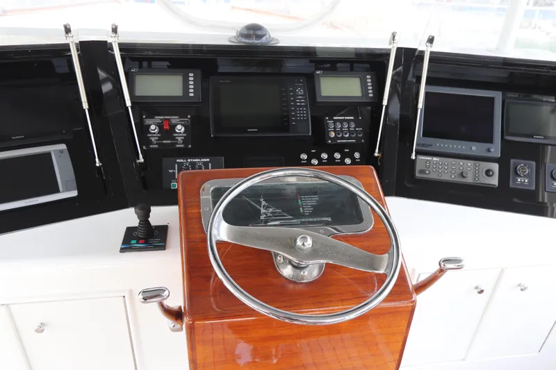 Slide: The Image of Control panel of a 2002 Buddy Davis 74 yacht with navigation instruments and steering wheel. - 44