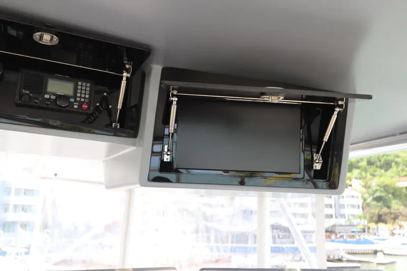 Slide: The Image of 2002 Buddy Davis 74 yacht interior with radio and monitor in overhead compartments. - 46