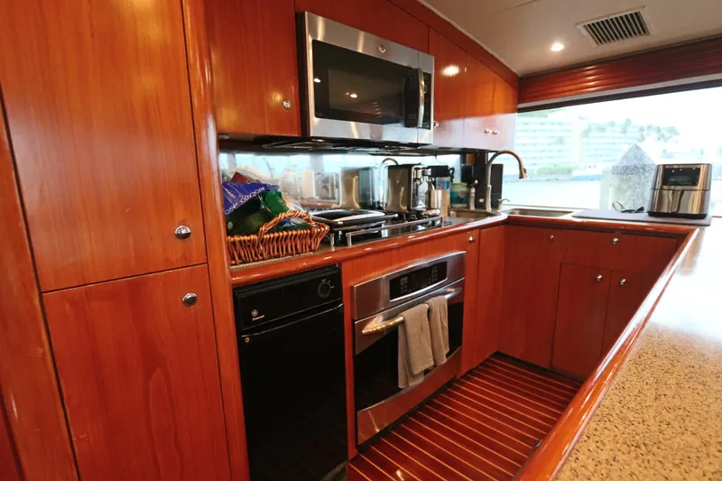Slide: The Image of Luxurious kitchen interior on a 2002 Buddy Davis 74 yacht, featuring modern appliances and wood cabinetry. - 8