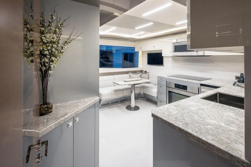Slide: The Image of Modern kitchen interior on 2023 Ocean Alexander 30R yacht with marble countertops and dining nook. - 30