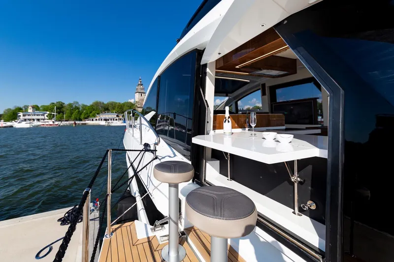 Slide: The Image of 2023 Galeon 470 Sky yacht docked with outdoor seating and table setup. - 11