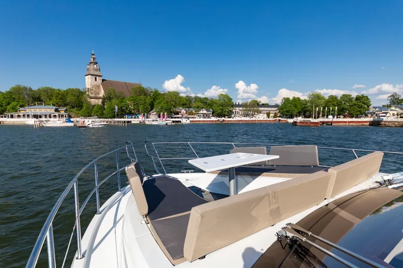 Slide: The Image of 2023 Galeon 470 Sky yacht with scenic waterfront and historic church in the background. - 14