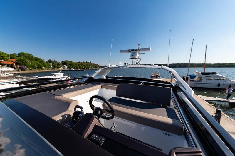 Slide: The Image of 2023 Galeon 470 Sky yacht at a marina, featuring a sleek helm and spacious seating. - 17