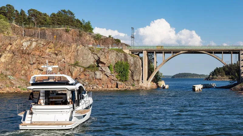 Slide: The Image of 2023 Galeon 470 Sky yacht cruising under a scenic bridge. - 6
