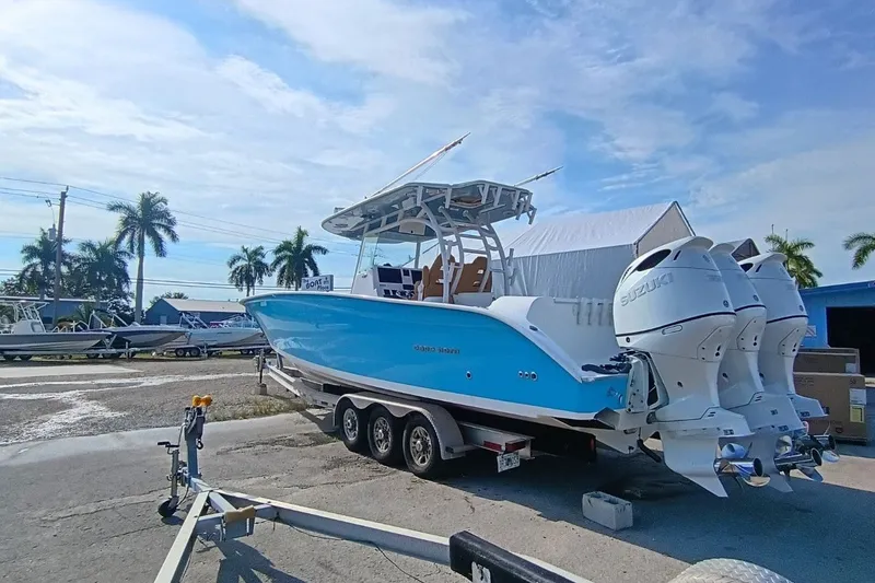 Slide: The Image of 2019 Cape Horn 36XS boat with triple Suzuki engines on a trailer, parked outdoors. - 3