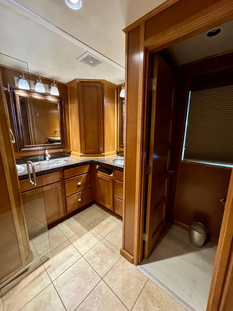 Slide: The Image of Luxurious bathroom in 2012 Bravada Helios Trip #7 with wooden cabinetry and granite countertops. - 12