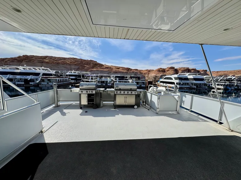 Slide: The Image of Deck view of 2012 Bravada Helios Trip #7 houseboat with grills, docked at marina. - 28