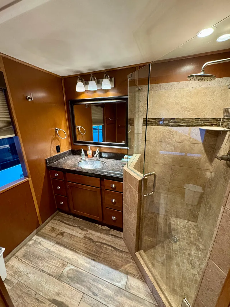 Slide: The Image of Luxurious bathroom in 2012 Bravada Helios Trip #7 with wooden cabinetry and granite countertops. - 8