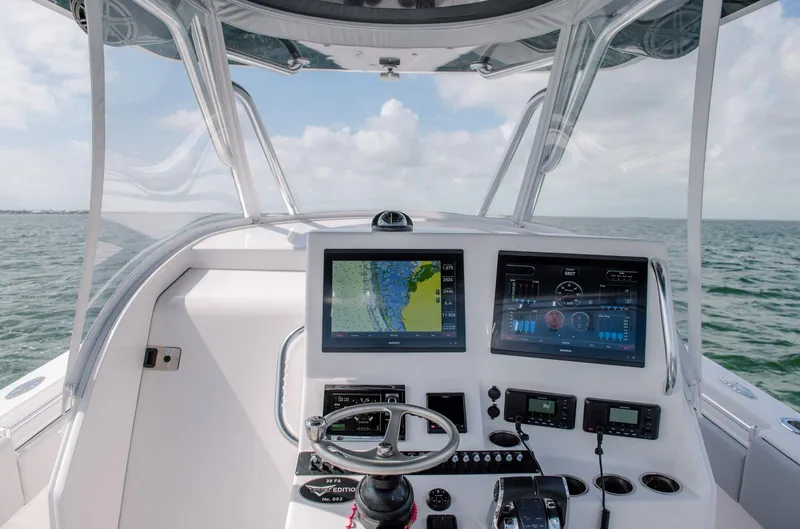 Slide: The Image of 2025 Contender 39 Fisharound boat dashboard with navigation screens on open water. - 21