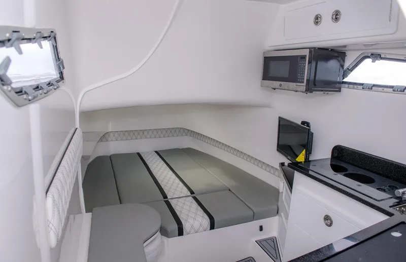 Slide: The Image of 2025 Contender 39 Fisharound cabin with bed, microwave, and TV. - 32