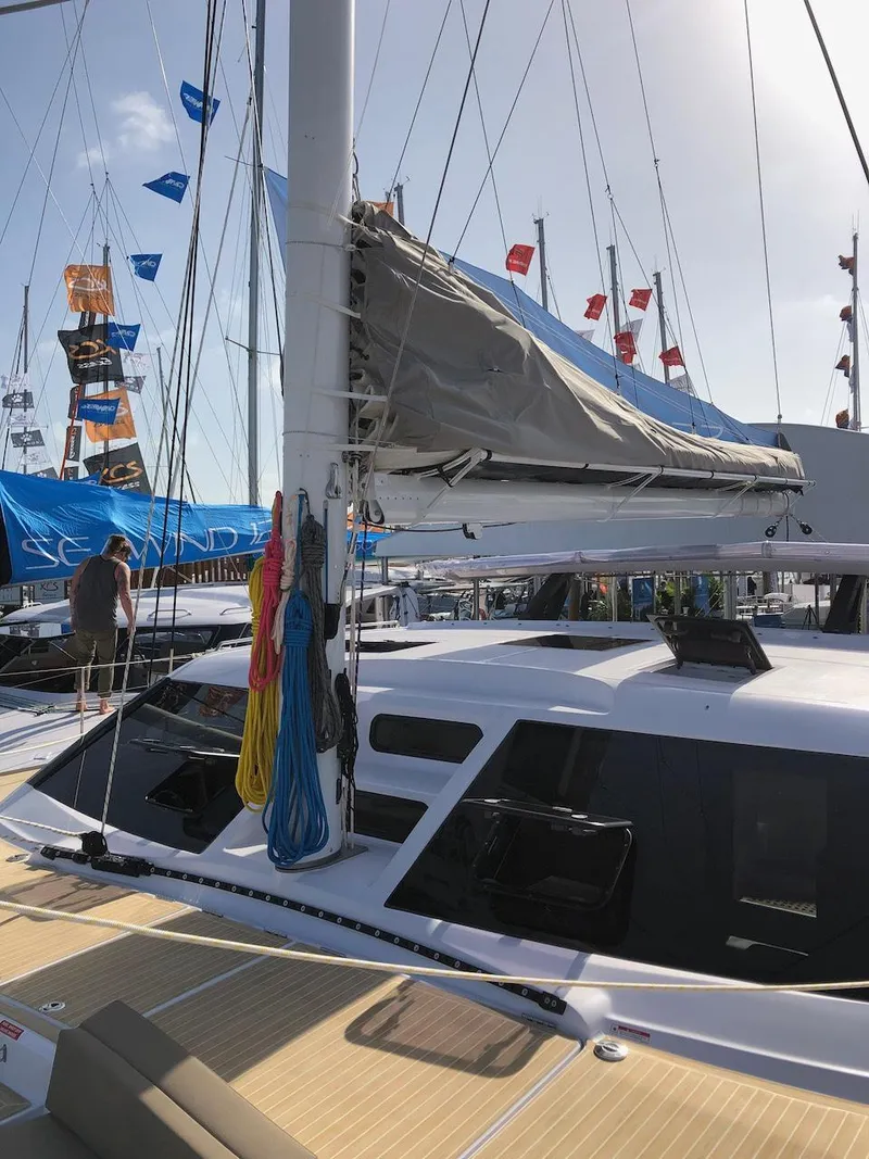 Slide: The Image of 2025 Seawind 1600 catamaran with sails and colorful ropes at a boat show. - 16