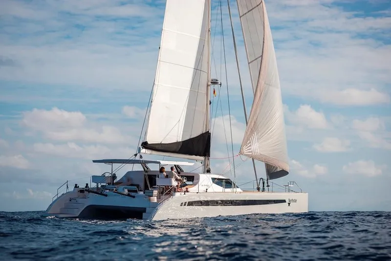 Slide: The Image of 2025 Seawind 1600 catamaran sailing on open sea under clear skies. - 25