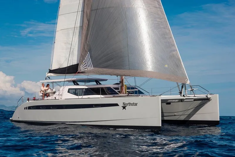 Slide: The Image of 2025 Seawind 1600 catamaran sailing on open sea under clear blue sky. - 29