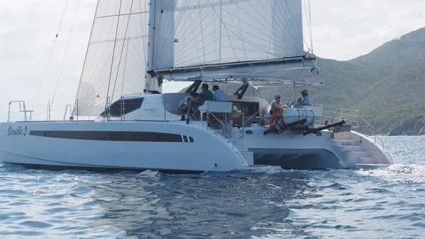 Slide: The Image of 2025 Seawind 1600 catamaran sailing on the ocean with crew onboard. - 30