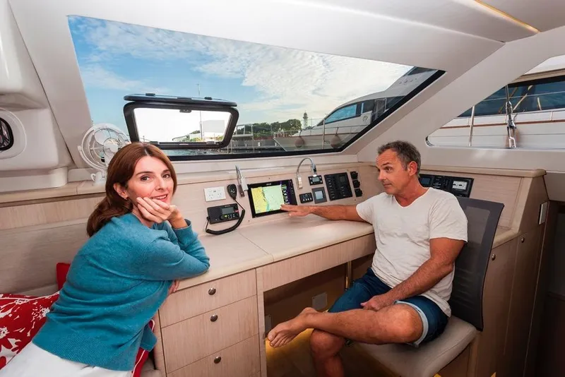 Slide: The Image of Couple inside 2025 Seawind 1600 yacht, enjoying the modern navigation system. - 46