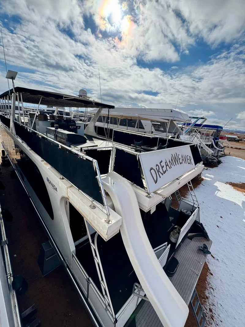 Slide: The Image of Houseboat "Dreamweaver" by Bravada, 2011 model, docked with snowy surroundings under a cloudy sky. - 32