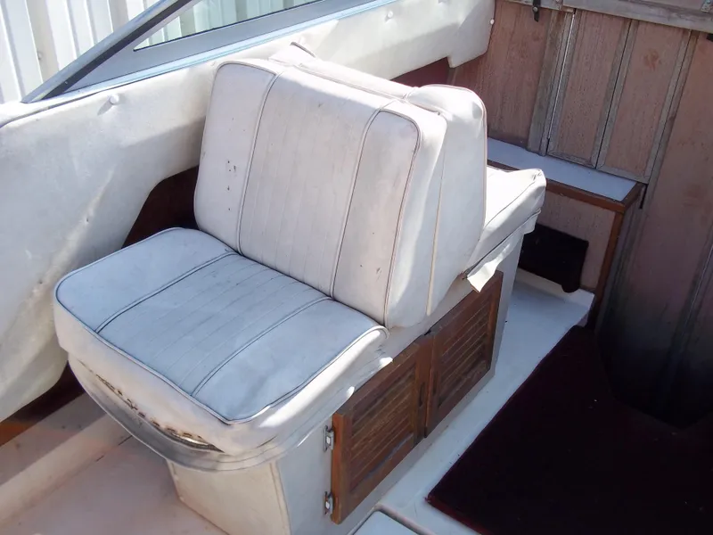 Slide: The Image of 1984 Sea Ray SRV 260 Sundancer boat interior with white cushioned seat. - 10