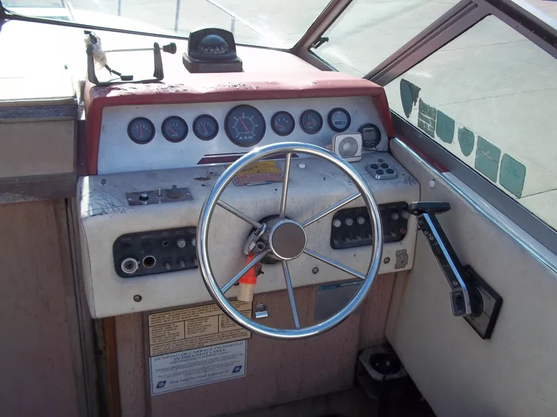 Slide: The Image of 1984 Sea Ray SRV 260 Sundancer boat helm with steering wheel and control panel. - 11