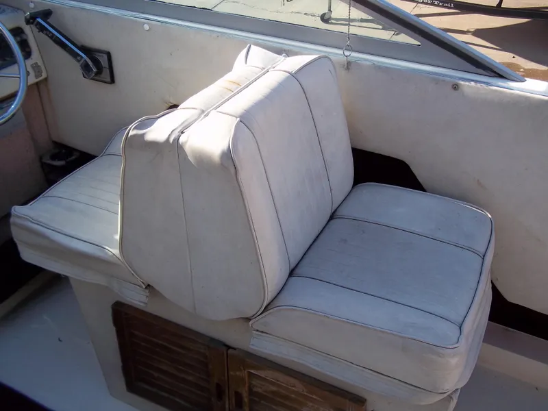 Slide: The Image of 1984 Sea Ray SRV 260 Sundancer cockpit seating with white cushions. - 13