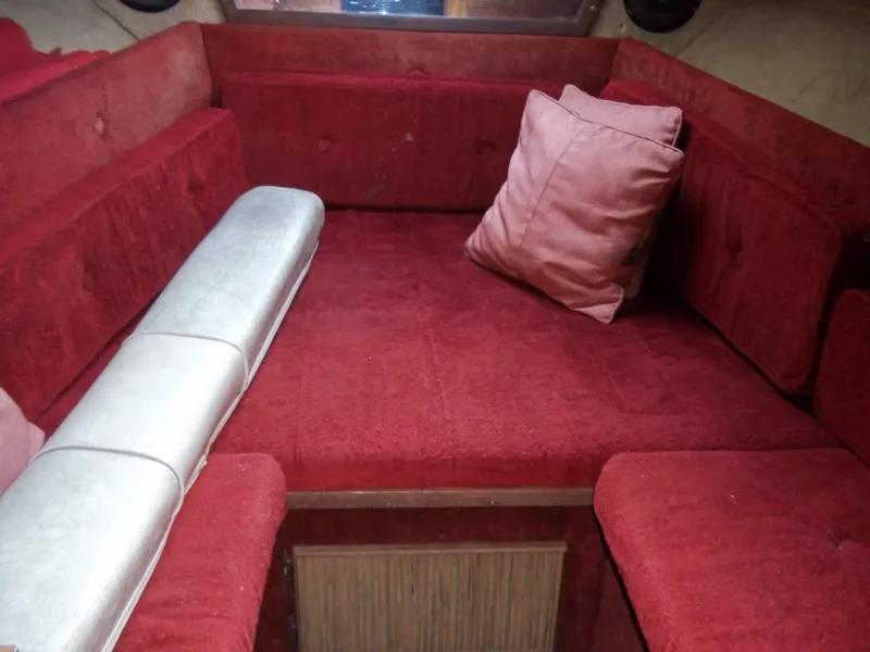 Slide: The Image of 1984 Sea Ray SRV 260 Sundancer interior with red upholstery and a pillow. - 16