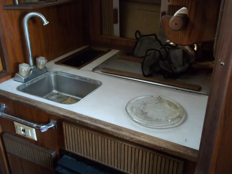 Slide: The Image of 1984 Sea Ray SRV 260 Sundancer boat kitchen with sink and stove. - 18