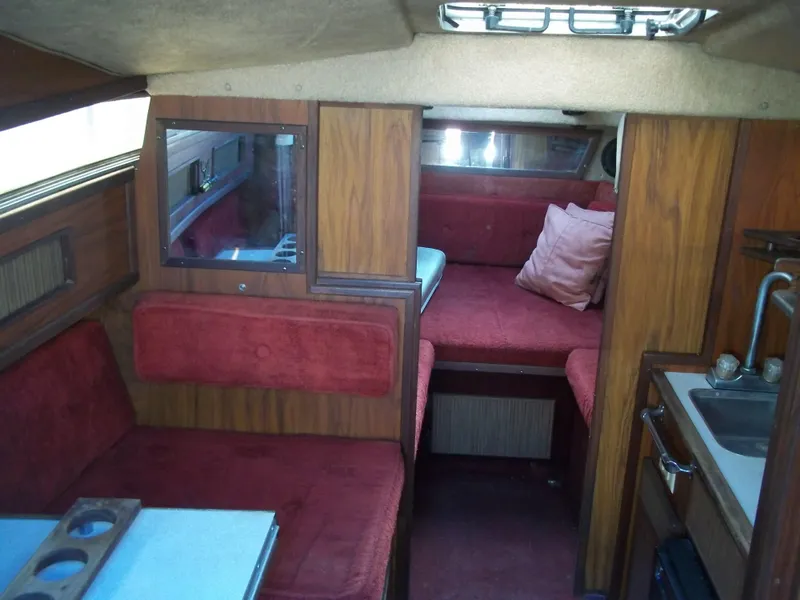 Slide: The Image of Interior of 1984 Sea Ray SRV 260 Sundancer with red seating and wooden cabinetry. - 21
