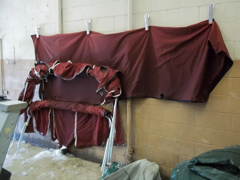 Slide: The Image of 1984 Sea Ray SRV 260 Sundancer maroon boat cover stored indoors. - 27