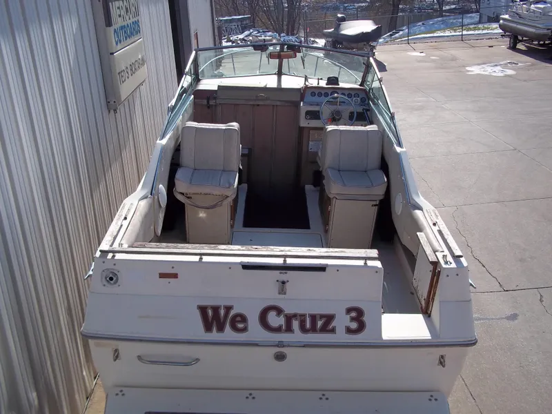 Slide: The Image of 1984 Sea Ray SRV 260 Sundancer boat, rear view, docked, with We Cruz 3 on the stern. - 4