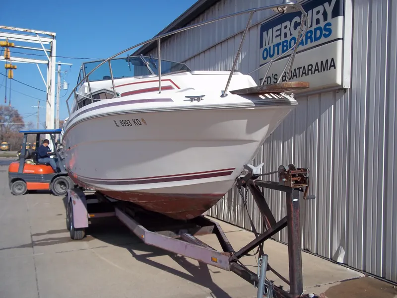 Slide: The Image of 1984 Sea Ray SRV 260 Sundancer on trailer at Mercury Outboards dealership. - 9