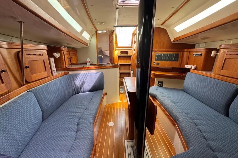 Slide: The Image of Interior of a 2004 C&C 110 sailboat with blue seating and wooden cabinetry. - 15