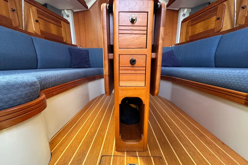 Slide: The Image of Interior of a 2004 C&C 110 sailboat with wooden cabinetry and blue seating. - 16