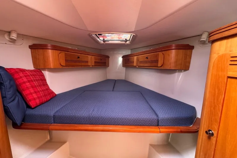 Slide: The Image of Cozy cabin interior of 2004 C&C 110 sailboat with blue bedding and wooden storage. - 20